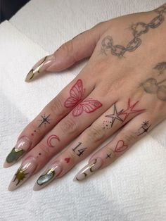 a woman's hand with tattoos on it and two different designs on her fingers