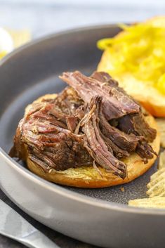 a roast beef sandwich with mustard and potato chips