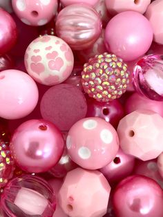 pink and white beads are in a bowl with gold flecks on it's sides