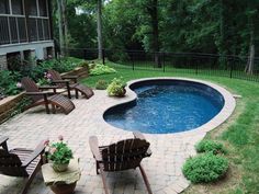 an above ground pool surrounded by lawn chairs and tables with flowers in the potted planter