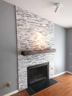 an empty living room with a fireplace and hardwood floors in the corner, painted blue