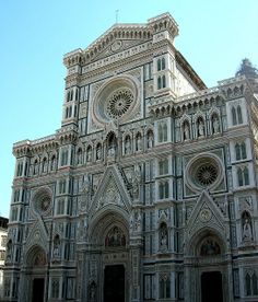 people are walking around in front of an ornate building