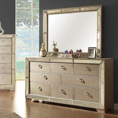 a dresser and mirror in a room with hardwood floors