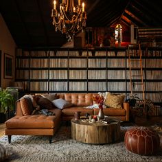 a living room filled with furniture and a chandelier hanging over the top of it