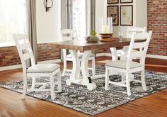 a dining room table with chairs and a rug