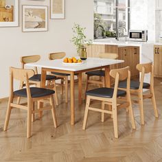 a kitchen table with chairs and fruit on it