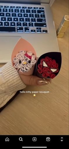 someone is holding some paper in front of a laptop computer with the caption hello kitty paper bouquet