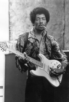 a black and white photo of a man playing an electric guitar