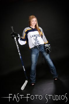 a woman posing for a photo with her skis and poles in front of black background