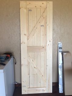 a wooden door sitting next to a refrigerator