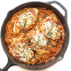 chicken parmesan in a skillet with tomato sauce and fresh herbs on top