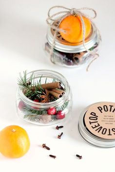 two jars filled with oranges and spices on top of a white table next to an orange