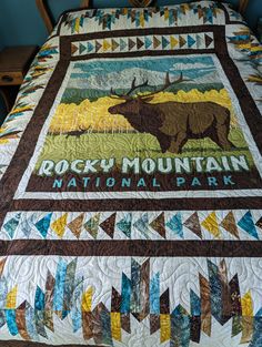 a bed with a quilt on top of it that says rocky mountain, national park