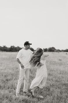 a man and woman standing in the middle of a field