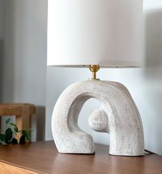 a white lamp sitting on top of a wooden table