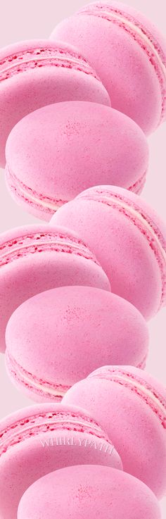 pink macaroons are lined up in rows