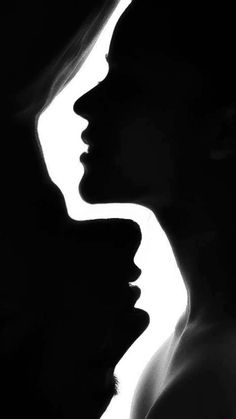 two women are silhouetted against a white background with their heads turned to the side