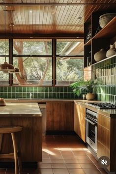 an image of a kitchen setting with green tiles on the walls and wood flooring