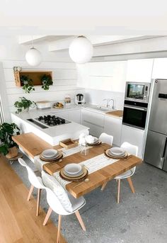 a kitchen with a table, stove and refrigerator next to an open floorplan