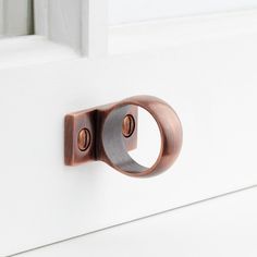 a close up of a door handle on a white door with a brown metal ring