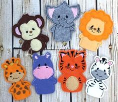 several felt animals are hanging from strings on a wooden surface with string attached to them