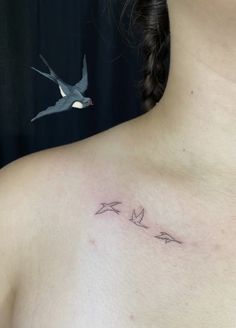 a woman's chest with three birds flying in the sky above her shoulder tattoo