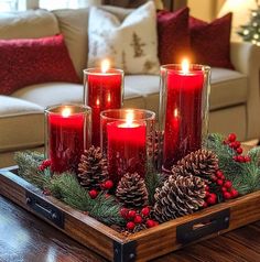 a tray filled with candles on top of a wooden table next to a christmas tree