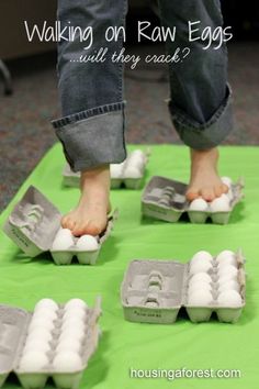 someone walking on raw eggs with their feet in the egg carton and another person standing over them