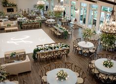 a large room with tables, chairs and chandeliers