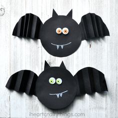 two bats made out of paper with googly eyes