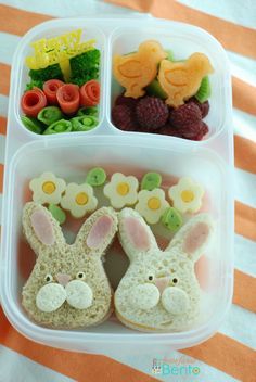 two plastic containers filled with food shaped like bunnies and flowers, carrots and broccoli