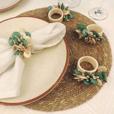 a place setting with napkin rings and flowers