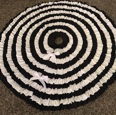 a black and white rug with ruffles on the floor in front of it