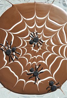 chocolate cake decorated with spider webs and black bugs on it's side, ready to be eaten