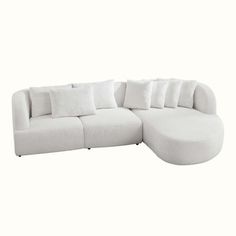 a large white couch with pillows on it's back and side ends, sitting in front of a white background