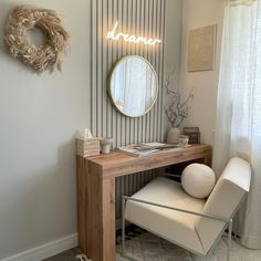 a desk with a mirror, chair and wreath on the wall in front of it