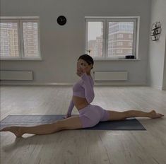 a woman sitting on a yoga mat in a room