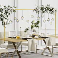 a dining table with white chairs and flowers on it