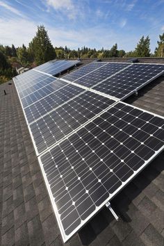 two solar panels on the roof of a house with trees in the background and blue sky