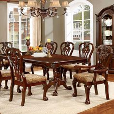 a dining room table with chairs and a china cabinet in the corner on top of a rug