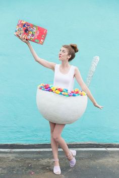 a woman in a costume made to look like a ballerina holding a box of candy