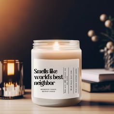 a candle sitting on top of a wooden table next to a book and some candles