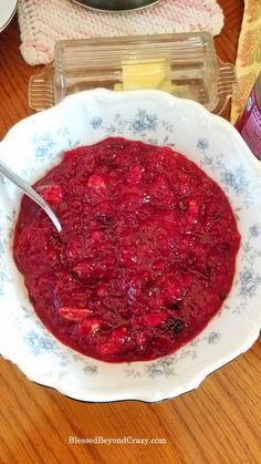 a bowl filled with cranberry sauce on top of a wooden table