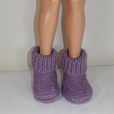 a doll's legs wearing purple knitted slippers