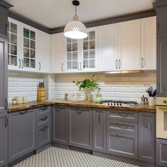 a kitchen with grey cabinets and white tile flooring is seen in this image from the front view