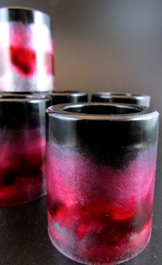 four glass cups with red and black dye on them