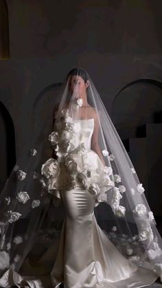 a woman in a wedding dress with flowers on her veil