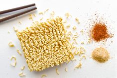 noodles and spices on a white surface with chopsticks