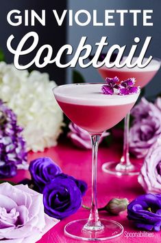 the gin violet cocktail is garnished with purple and white flowers on a pink tablecloth