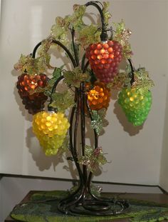 a vase filled with lots of different colored fruit